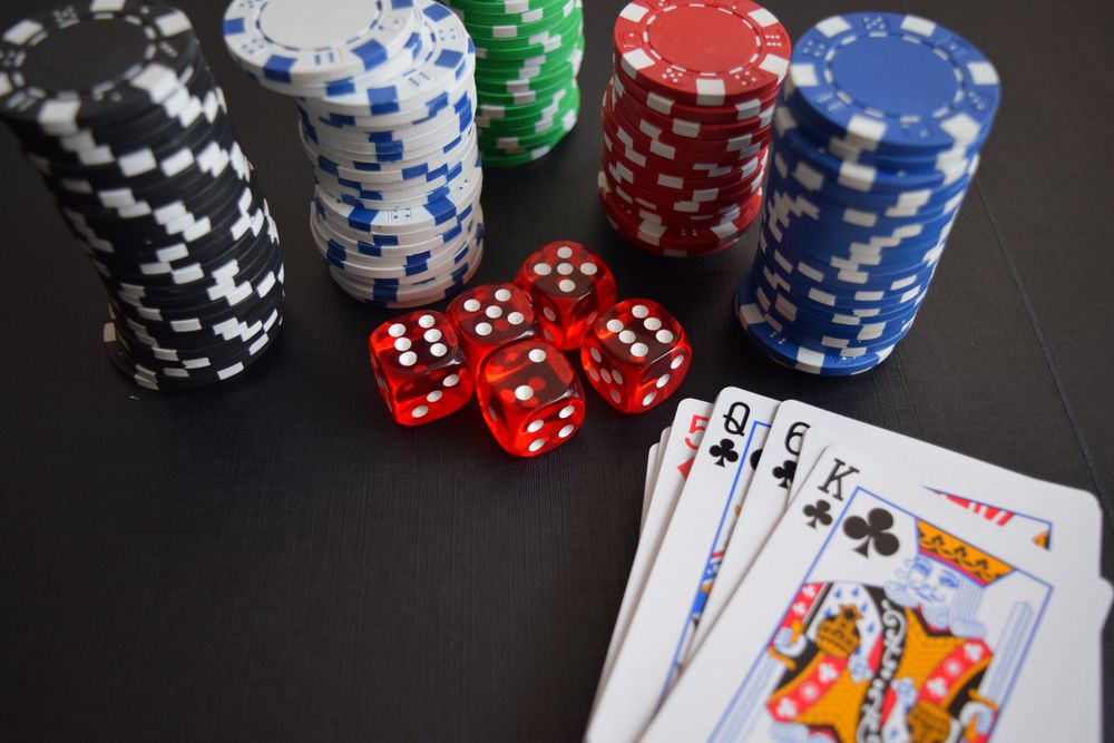 Chip, dadu, dan kartu di atas meja gelap